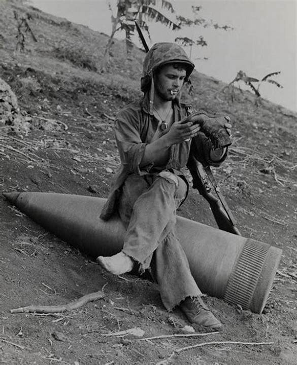 Soldier Resting on Unexploded 16-Inch Shell, Saipan.jpg